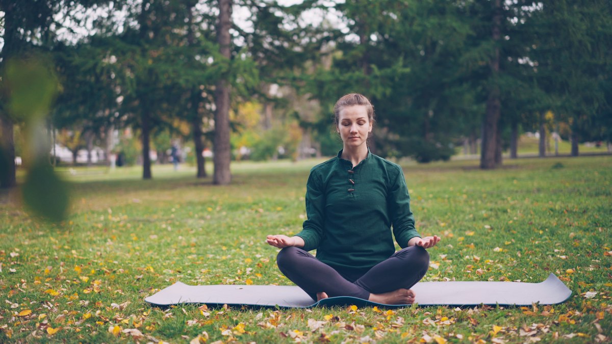 Woman meditating peacefully in a park — photo by Vitaly Gariev on Unsplash